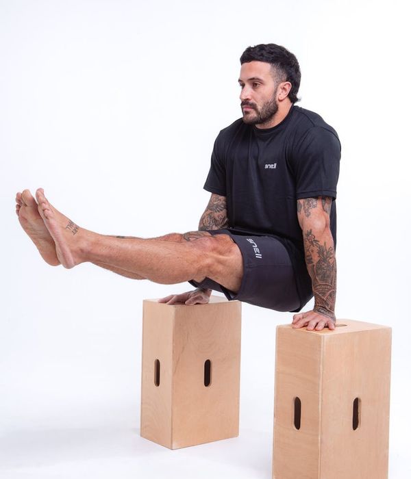 Man performing a controlled strength exercise in a modern gym setting.